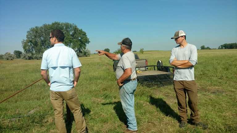 Ducks Unlimited intern William Palarski (right) discusses DU conservation programs with a North Dakota farmer