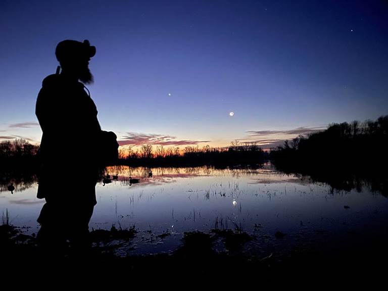 A hunter watches a sunrise at Gray Lodge Wildlife Area in California.